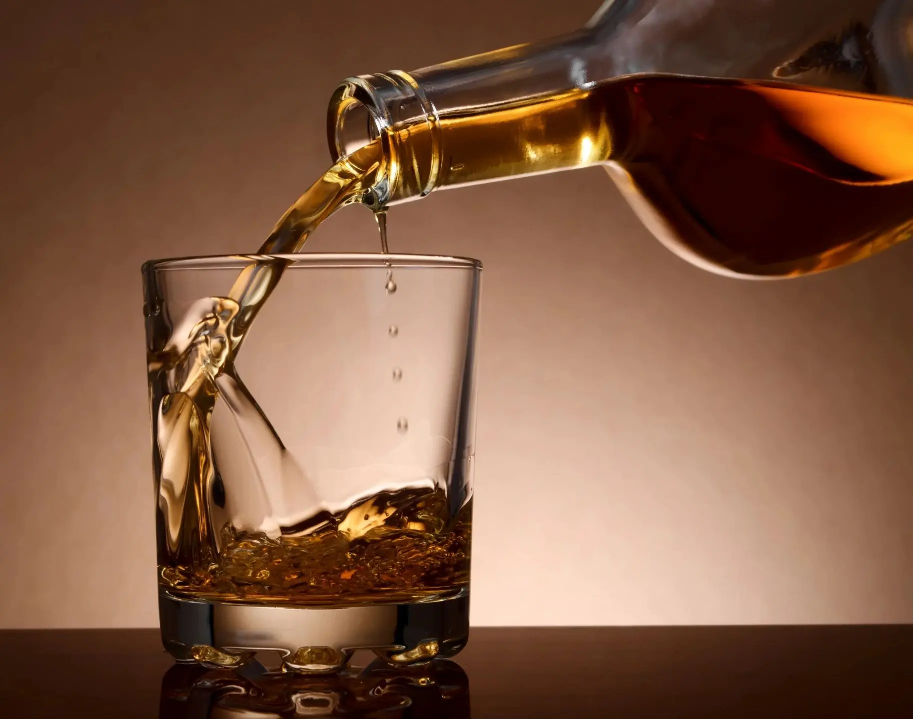 Alcohol being poured into a glass, highlighting the alcohol addiction warning signs to watch for.