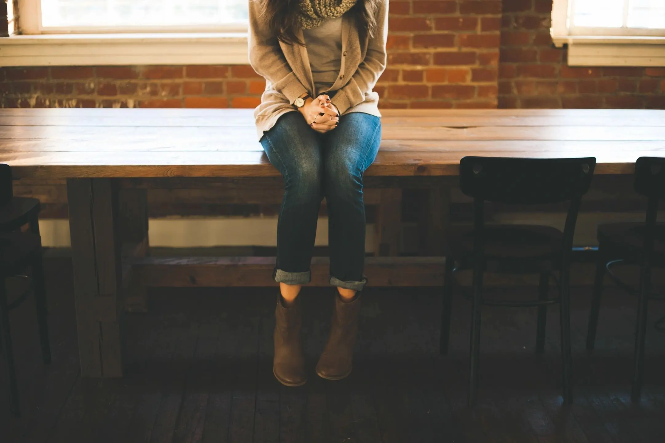 Person sitting on a table, symbolizing the journey to discover medication-assisted treatment for recovery.