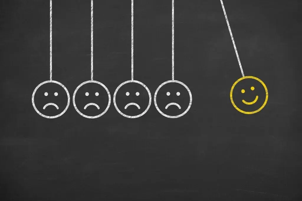 Illustration of frowning faces transforming into a smiling face, symbolizing CBT cognitive behavioural therapy.